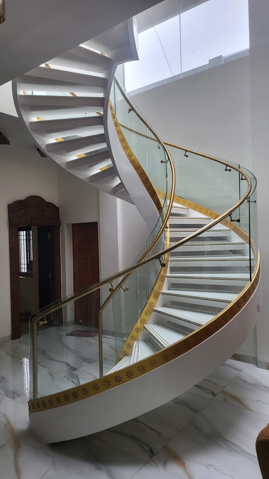Custom white marble-finish helical metal staircase in Chennai, Tamil Nadu